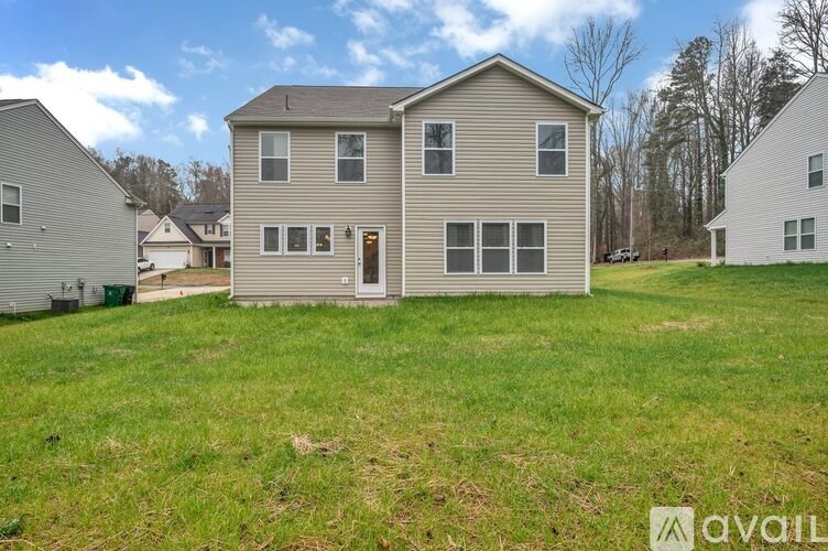 A house with a brown roof and grey siding is for sale.