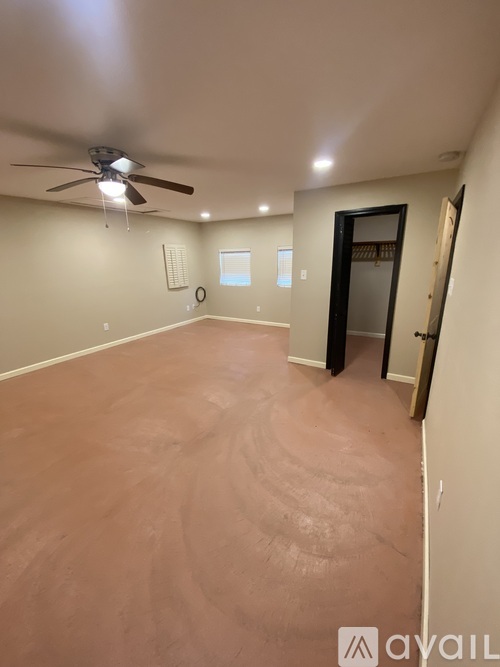 A room with a ceiling fan and a door.