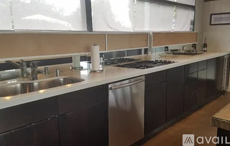 A kitchen with a stainless steel sink and a stove top oven.