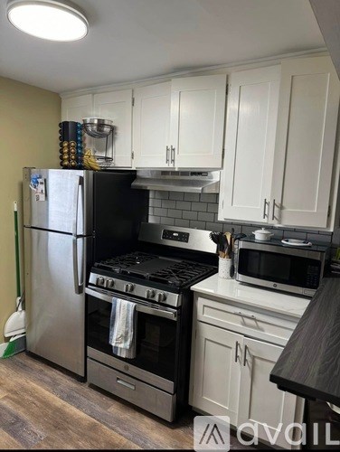A kitchen with a stainless steel refrigerator, oven, and microwave.