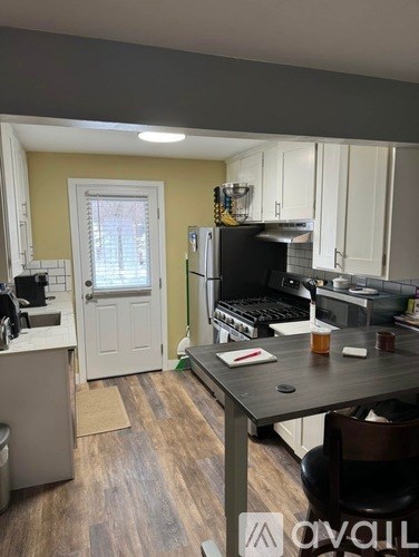 A kitchen with a table and chairs in front of it.
