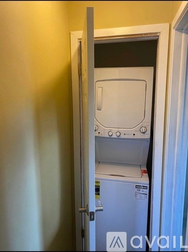 A white dishwasher is installed in a narrow space between two walls.