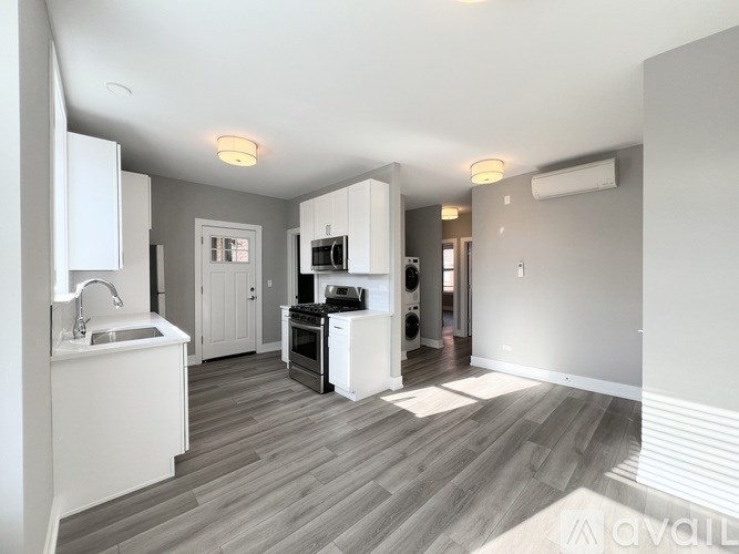 A modern kitchen with white appliances and a wooden floor.
