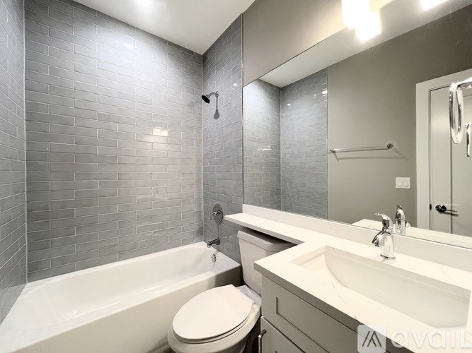 A white toilet sits next to a bathtub in a bathroom.