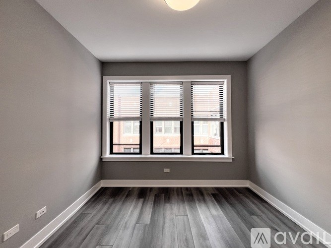 A room with a window and wooden flooring.