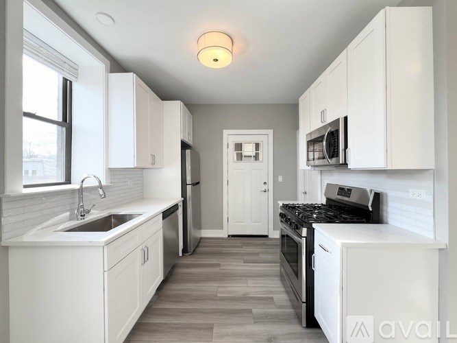 A kitchen with white cabinets and a black stove top oven.