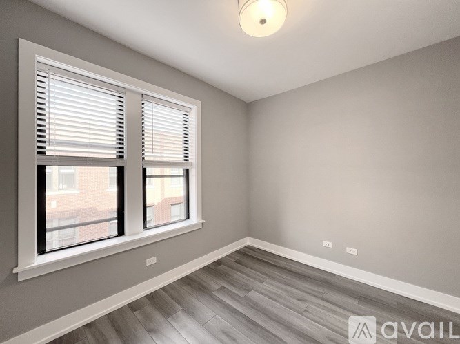 A room with a window and wooden flooring.