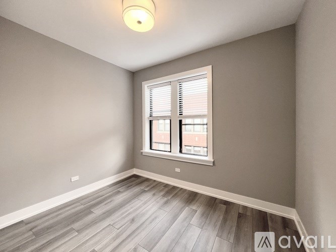 A room with a window and wooden flooring.
