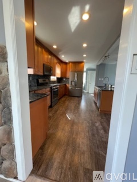 A kitchen with wooden cabinets and a stone pillar.