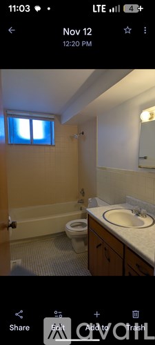 A bathroom with a toilet, sink, and mirror.