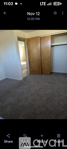 A room with a carpeted floor and a wooden door.