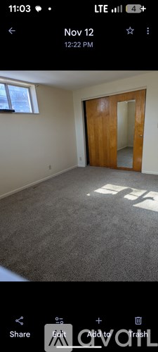 A room with a carpeted floor and a wooden door.