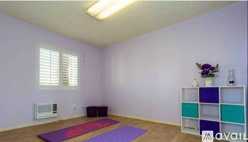 A room with purple walls and a yoga mat on the floor.