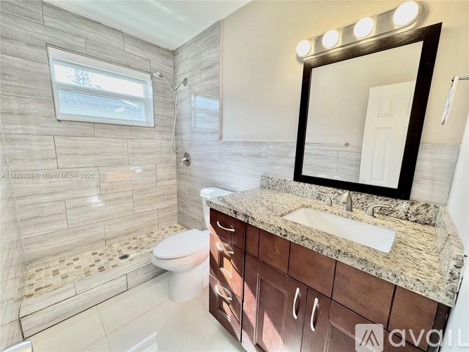 A bathroom with a toilet, sink, and a mirror.