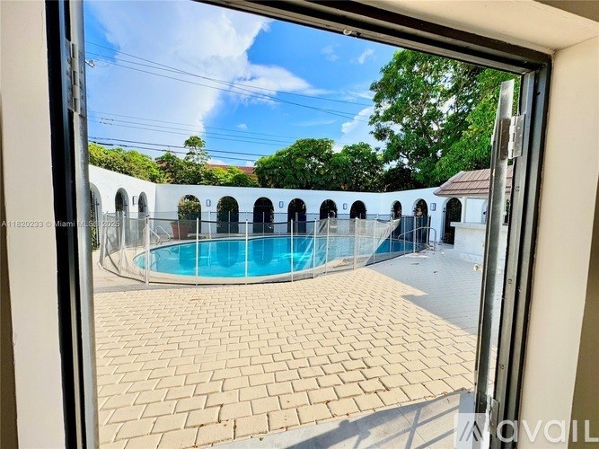 A pool is seen through a glass door.