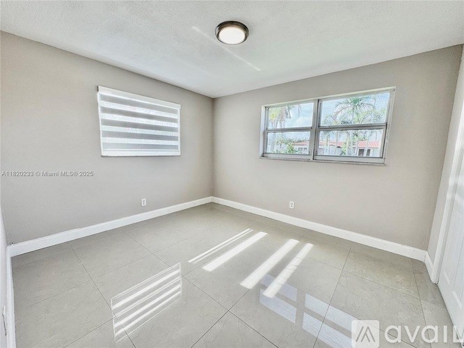 A room with a window and a wall-mounted air conditioner unit.