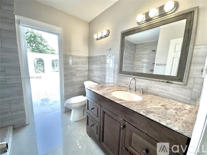 A bathroom with a sink, mirror, and toilet.