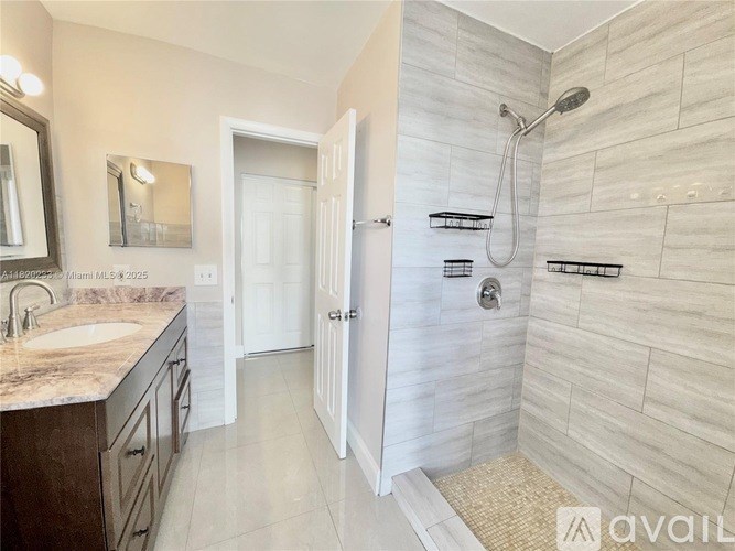 A bathroom with a marble countertop and a walk-in shower.