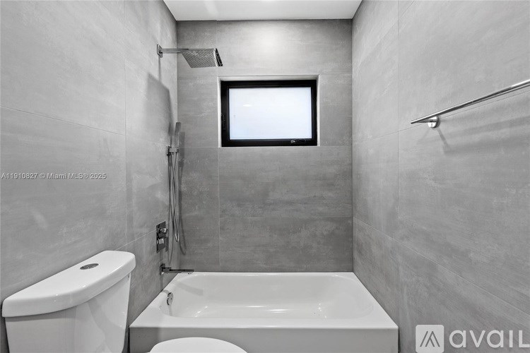 A bathroom with a tub, toilet, and shower.