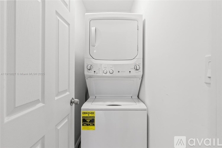 A white washing machine with a yellow caution label on the door.