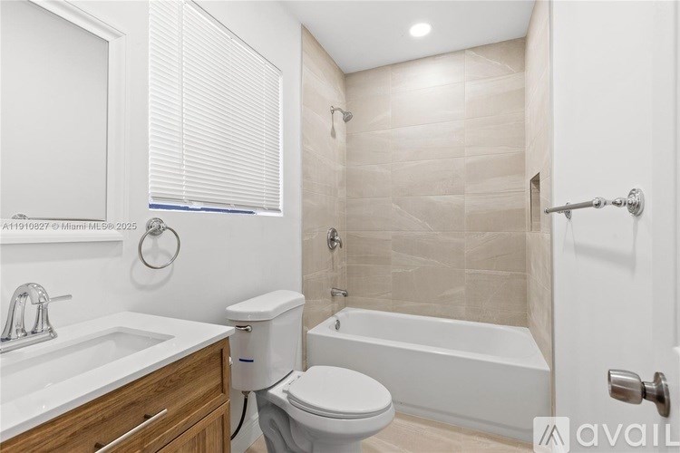 A bathroom with a toilet, sink, and bathtub.