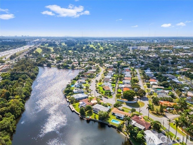 A river flows through a residential area with houses on both sides.