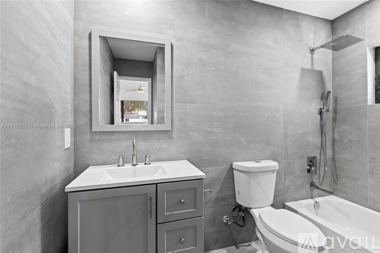 A bathroom with a white sink and grey cabinet.