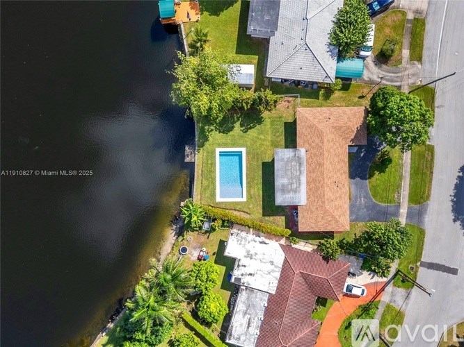 A bird's eye view of a residential area with a swimming pool and a house with a red roof.