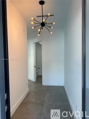 A long hallway with a chandelier hanging from the ceiling.
