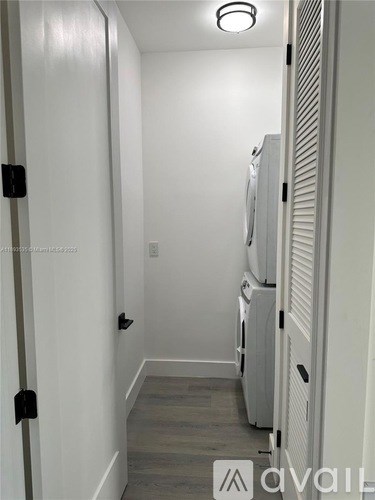A hallway with a refrigerator on the right side.