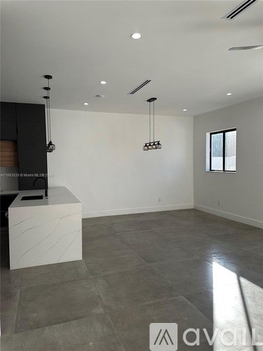 A modern living room with a white counter and grey tiled floor.