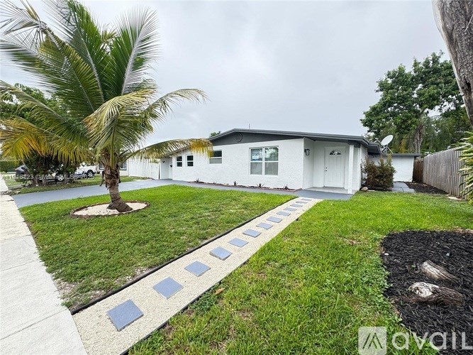 A white house with a palm tree in front of it.