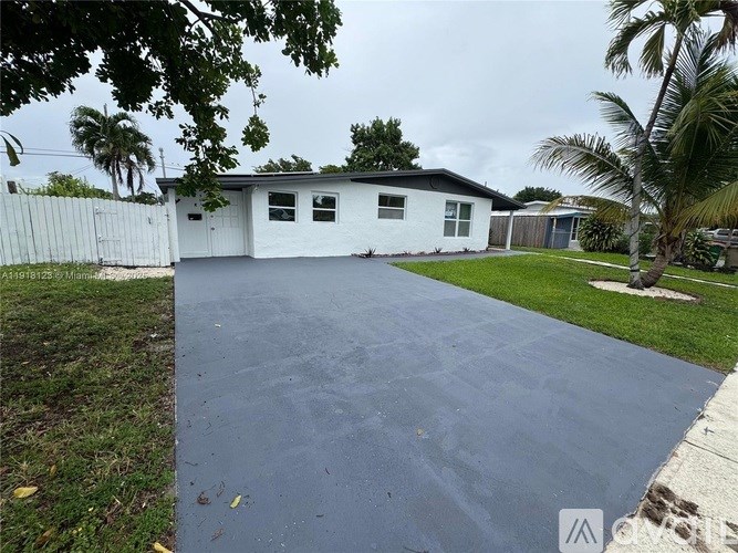 A white house with a driveway in front.
