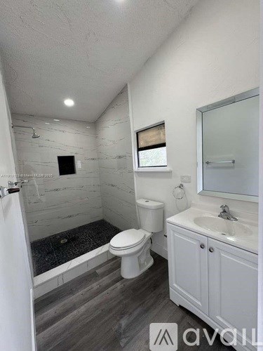 A bathroom with a toilet, sink, and bathtub.