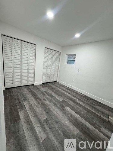 A room with a wooden floor and white walls.