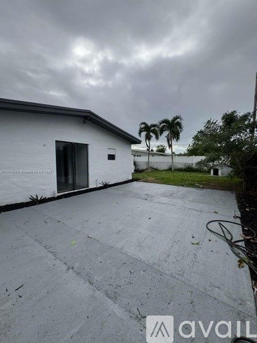 A white building with a dark roof and a grey sky above.