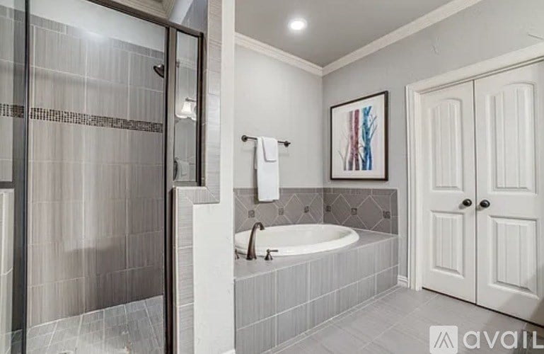 A bathroom with a white tub and a white door.