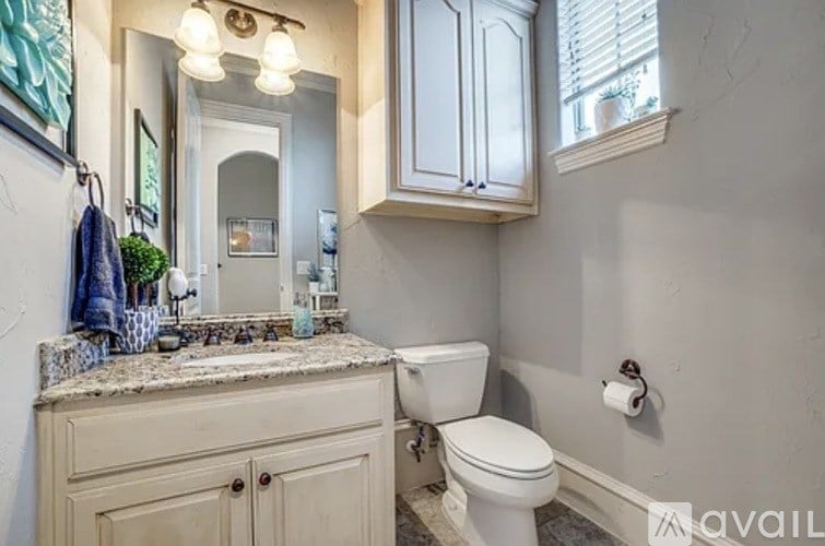 A bathroom with a toilet, sink, and mirror.