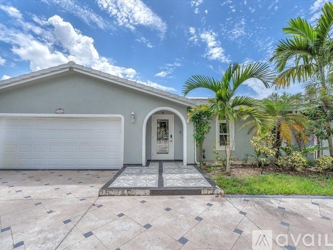 A house with a white garage door and a tiled driveway.