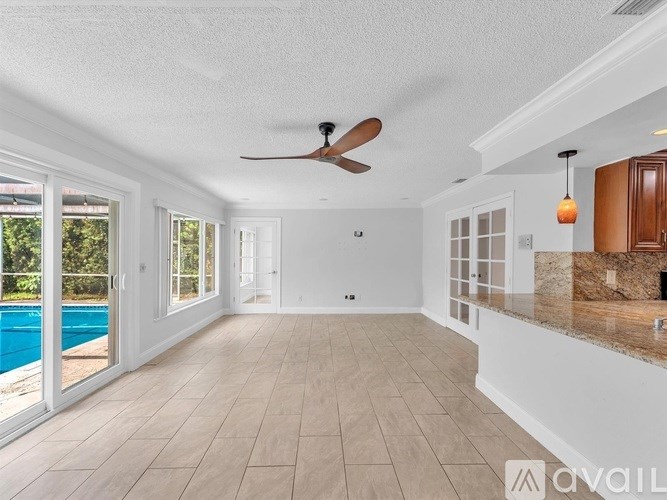 A spacious room with a pool and a ceiling fan.
