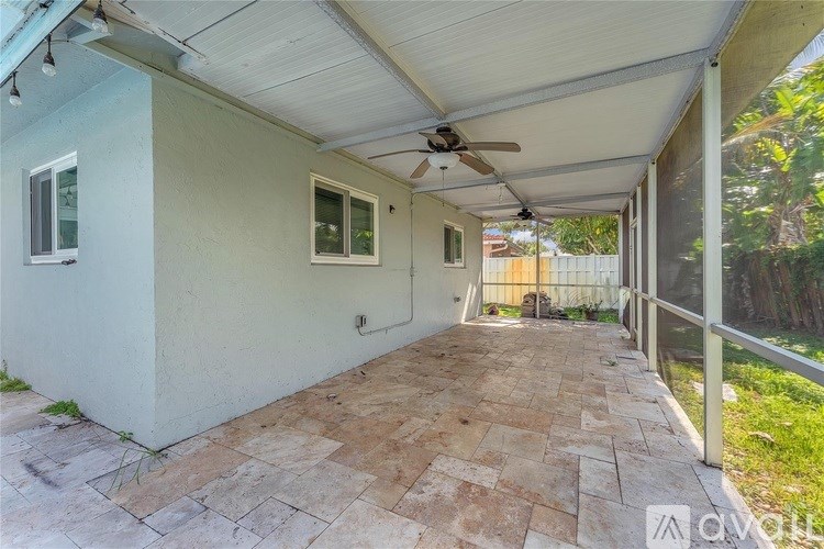 A patio area with a fan and a tiled floor.