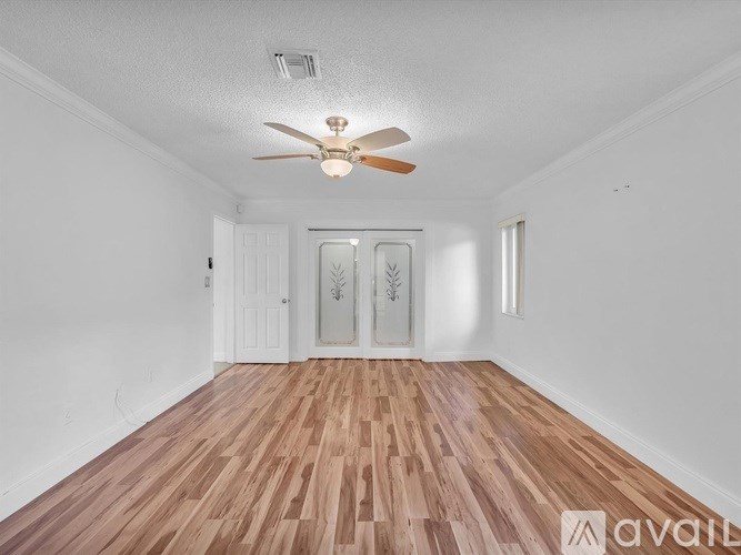 A room with wooden flooring and a ceiling fan.