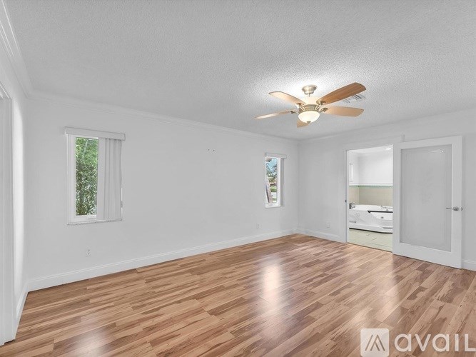 A room with wooden flooring and a ceiling fan.