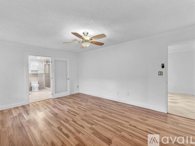 A room with wooden flooring and a ceiling fan.