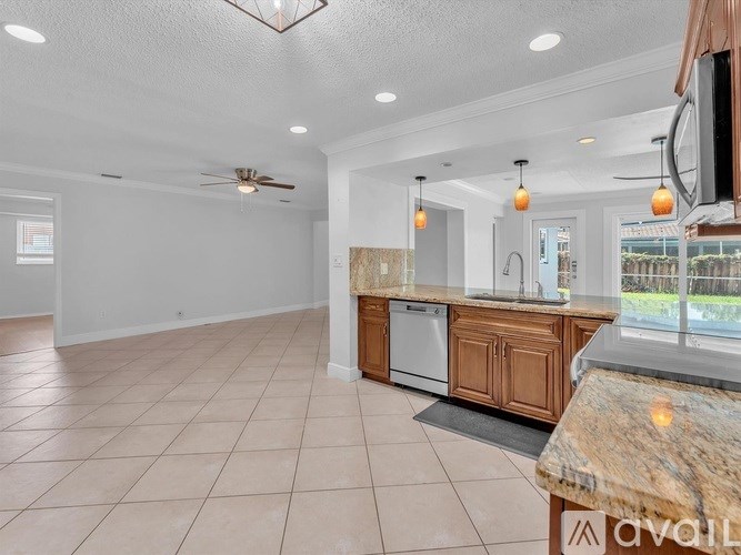 A kitchen with a marble countertop and a ceiling fan.