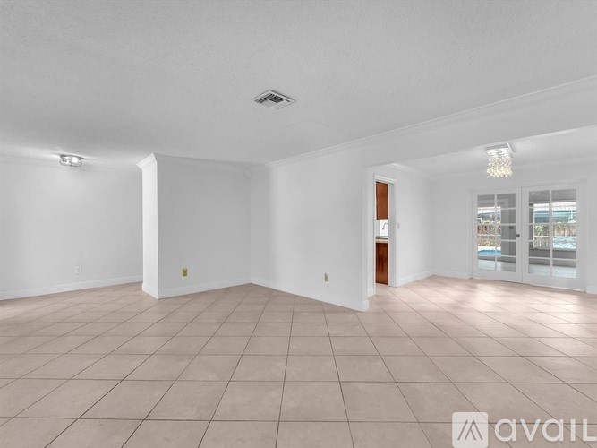 A spacious room with tiled flooring and a ceiling light fixture.