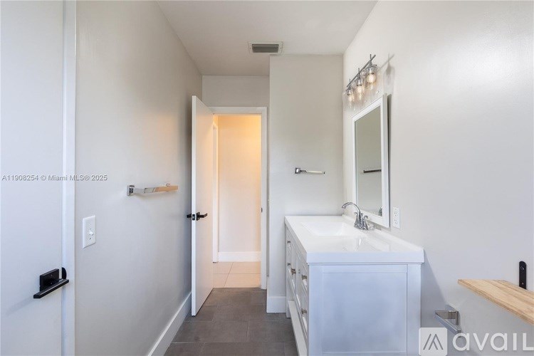 A bathroom with a white sink and a mirror above it.