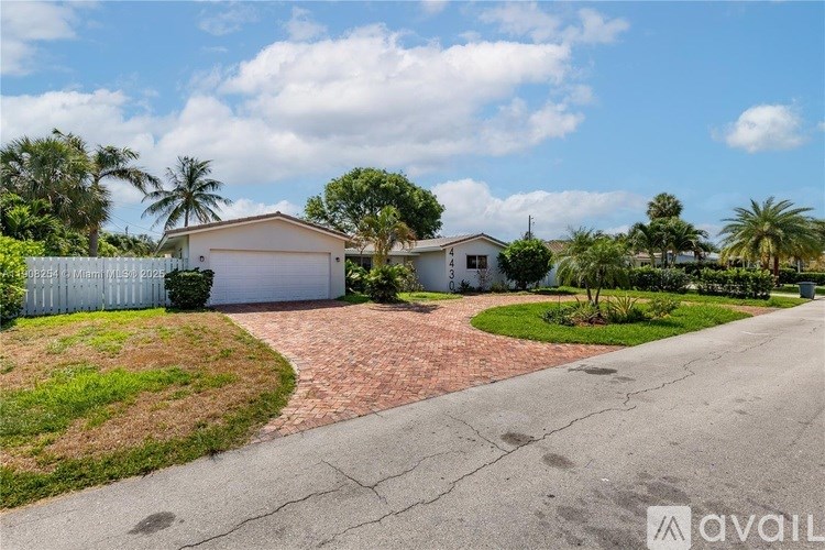 A house with a driveway and a fence is available for sale.