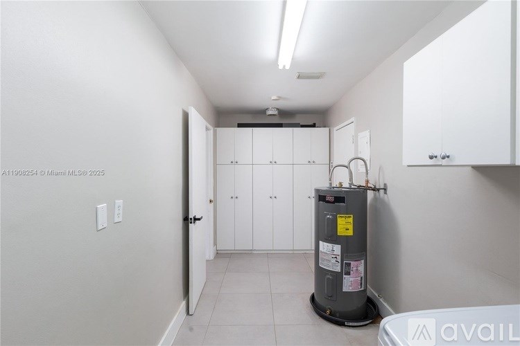 A room with a water heater on the floor.