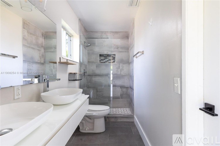 A bathroom with a white sink and toilet.
